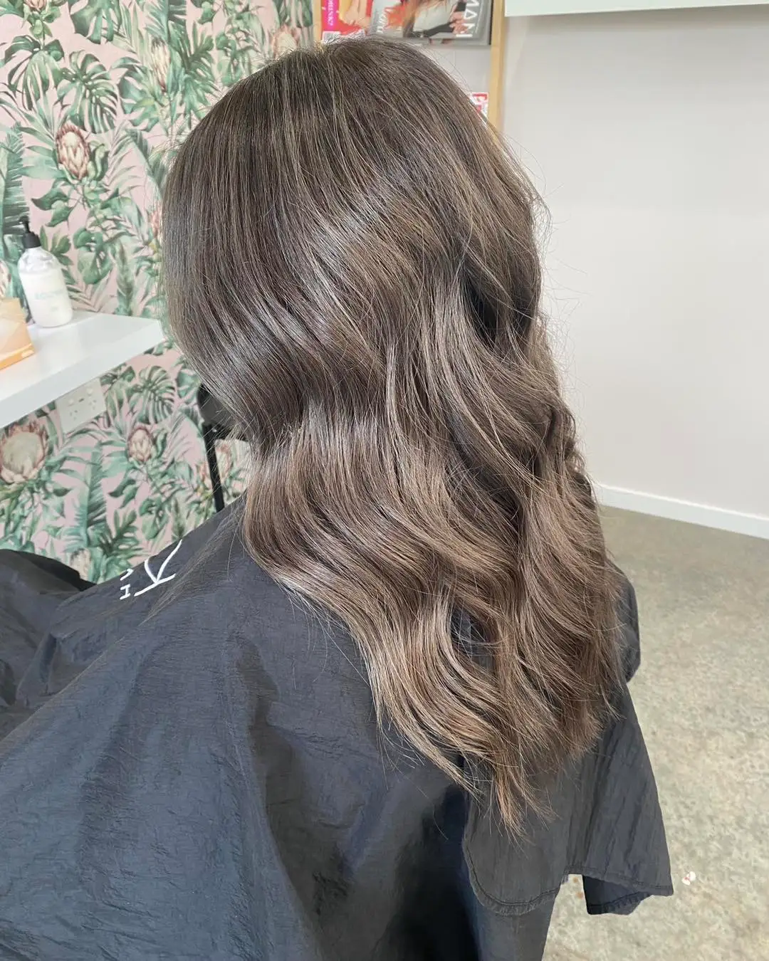 Side view of cool ash grey-brown waves on shoulder-length hair