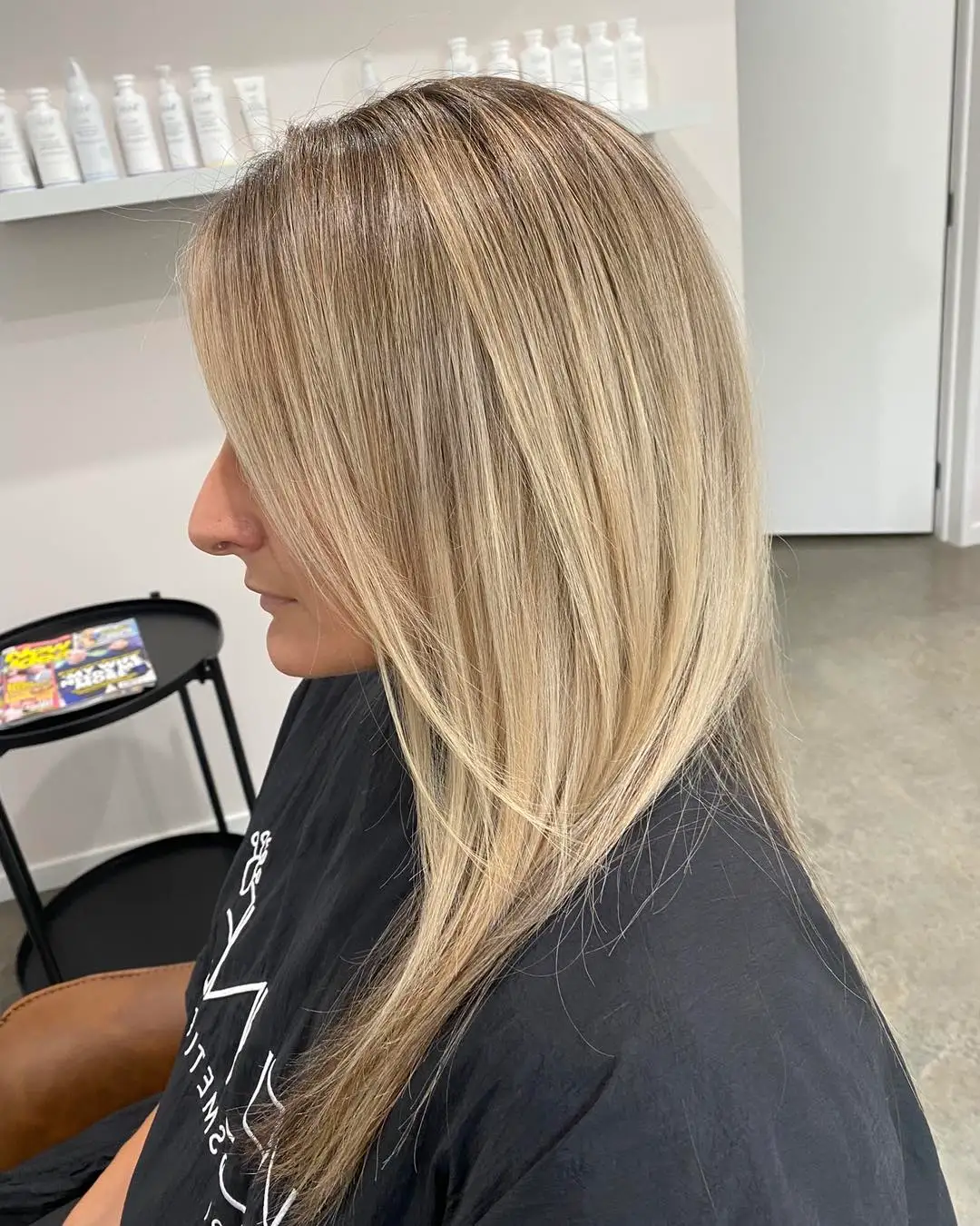Side portrait of bright blonde balayage with creamy mid-lengths