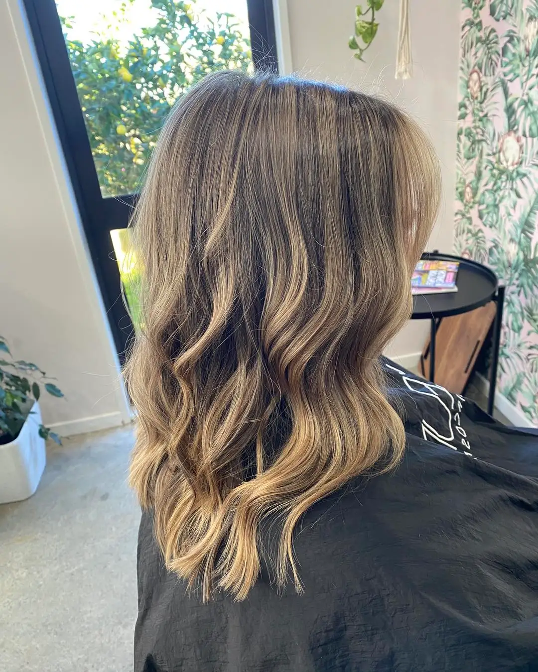 Back view of mid-length lived-in bronde balayage with beachy waves