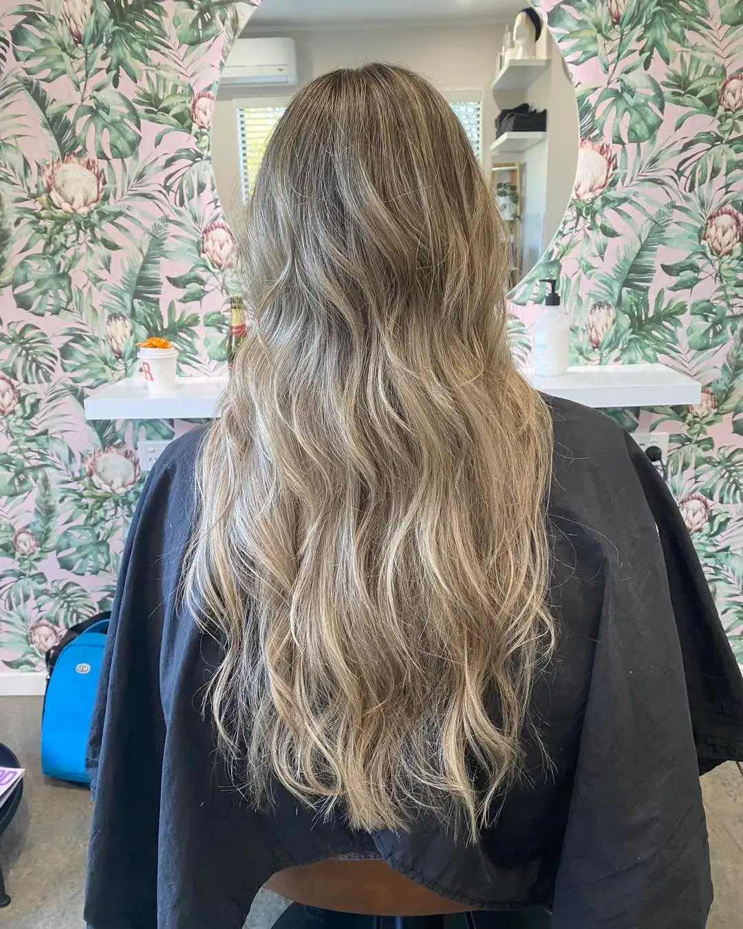 Back view of very long cool blonde balayage with relaxed waves