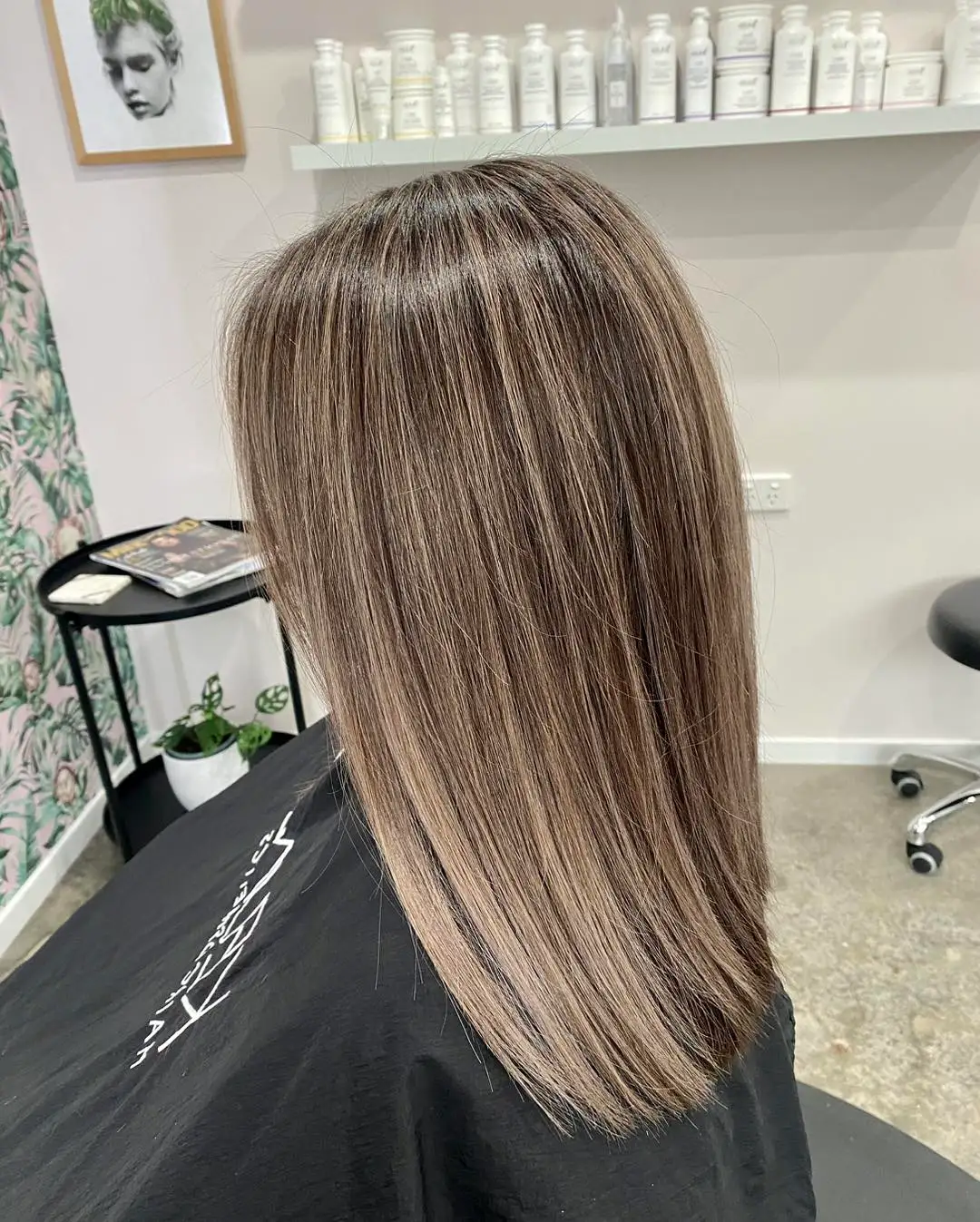 Side view of sleek mid-length mushroom brown hair with subtle highlights