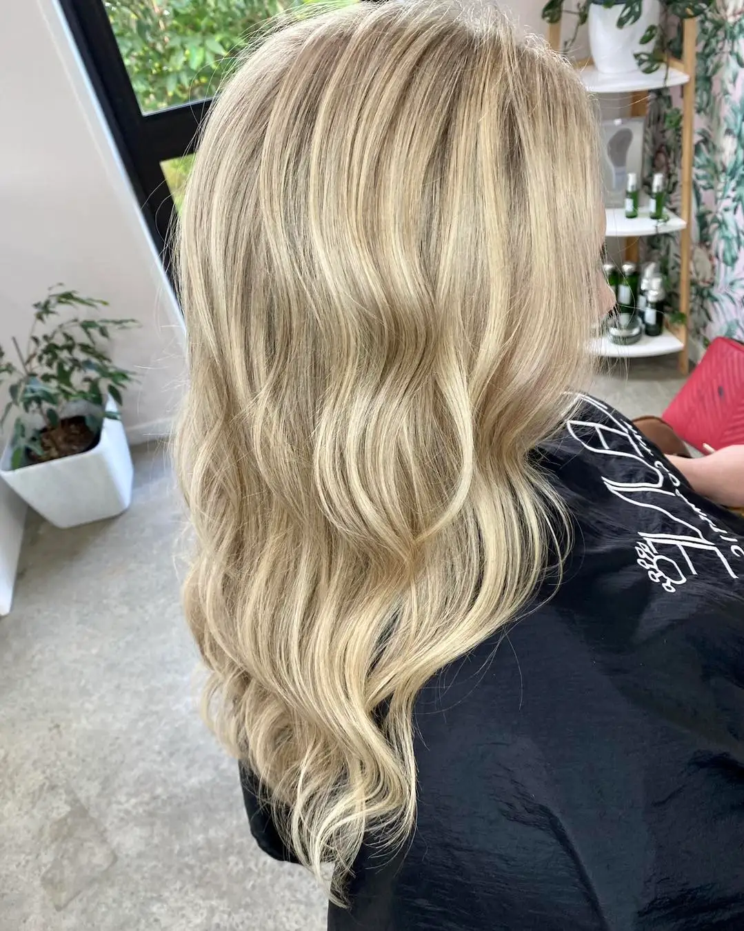 Side view of long platinum blonde balayage with soft waves