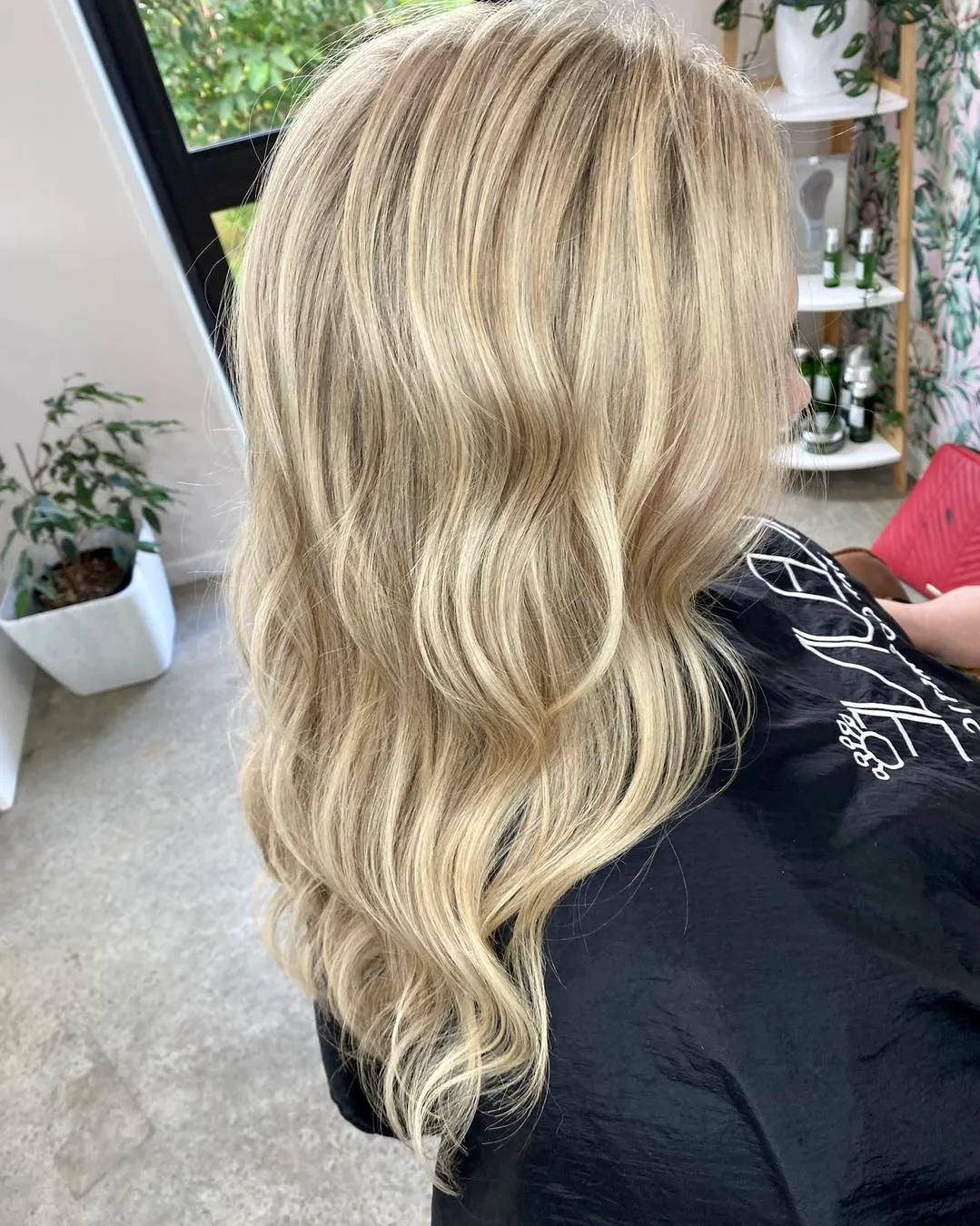 Side view of long platinum blonde balayage with soft waves