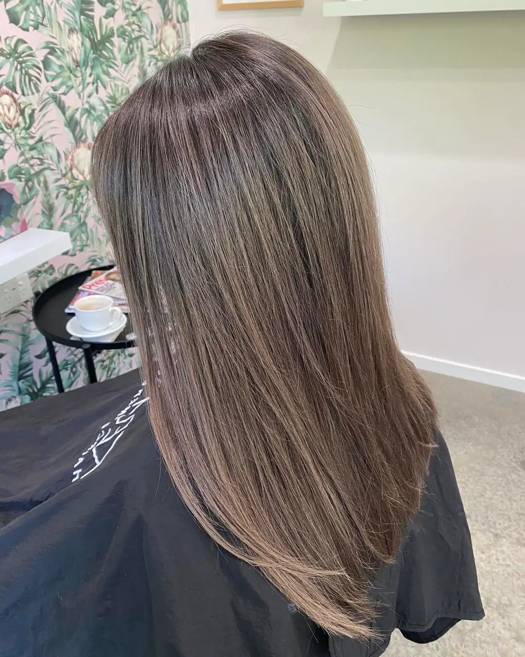 Side view of sleek smoky ash brown balayage fading to light ends