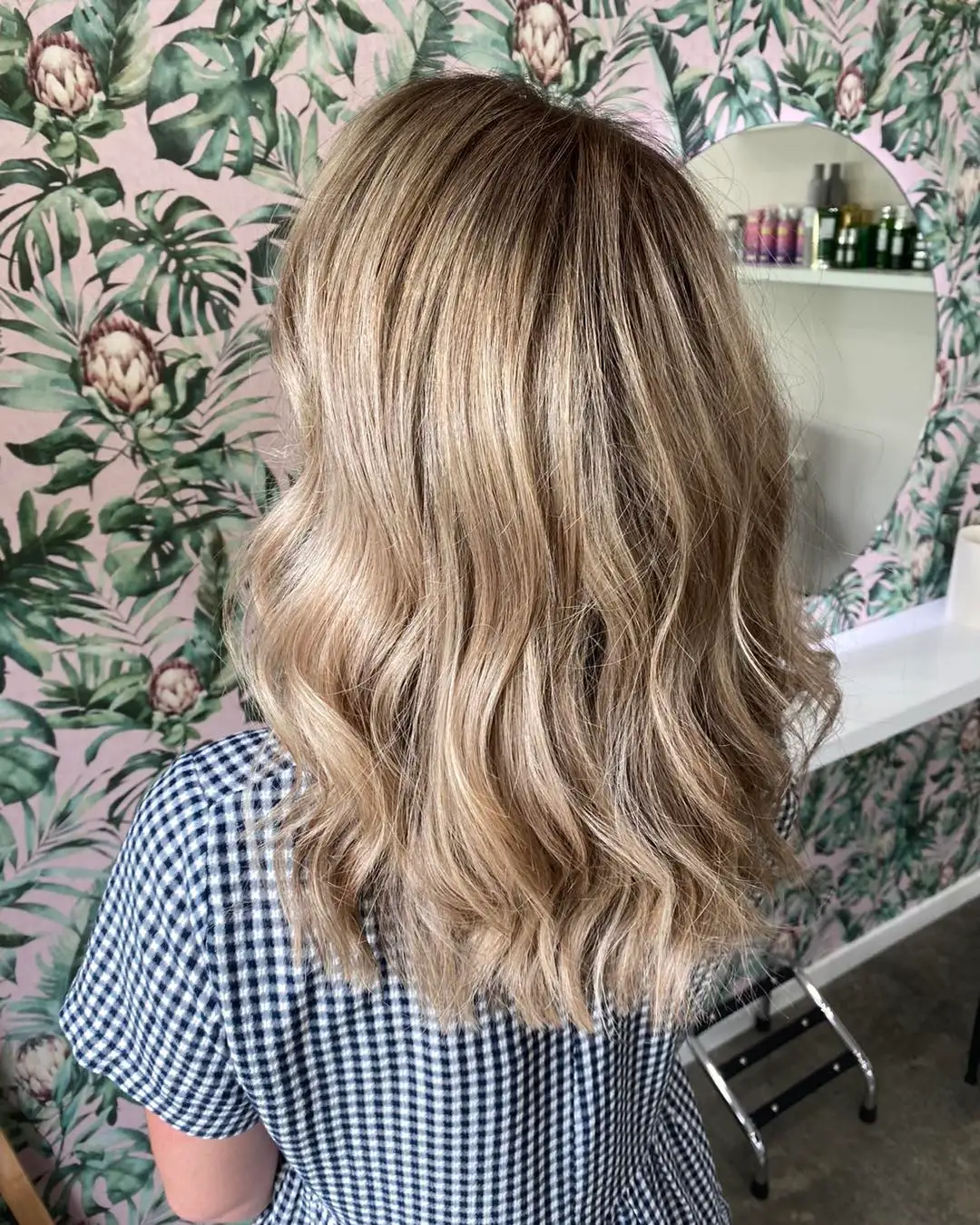 Side back view of soft blonde balayage with loose beachy waves